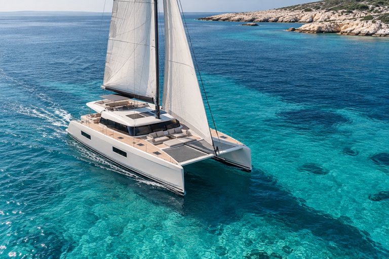 Sailing catamaran crossing clear Mediterranean water